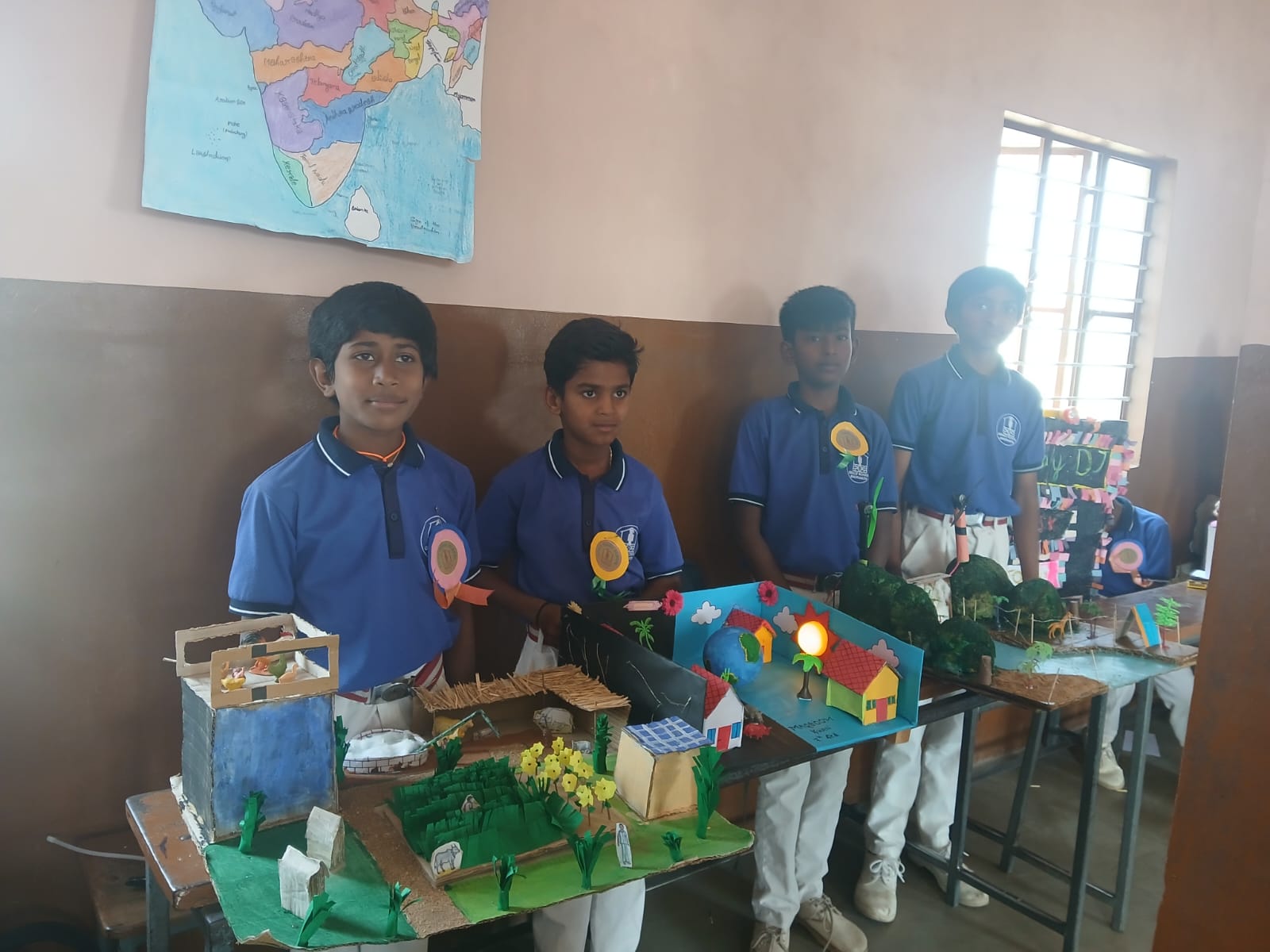Three boys exhibit detailed models of wind energy and the Indian judicial system.